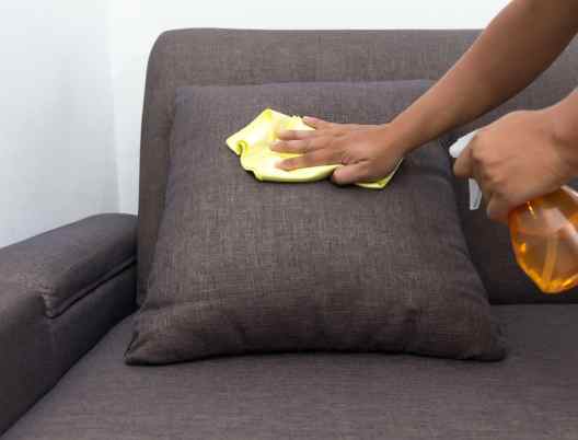 person-scrubbing-upholstered-pillow-with-a-cleaning-solution